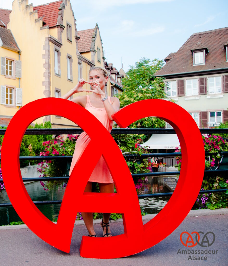 Ambassadrice d'Alsace posant derrière un A-coeur